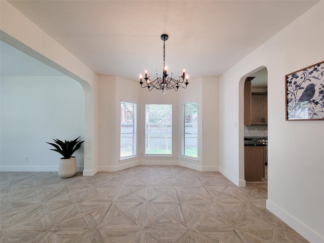 218 Windrift Ct, Sugar Land, TX 77479 - unfurnished dining area with arched walkways, a chandelier, and baseboards