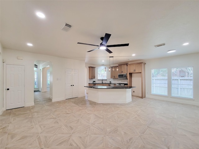 218 Windrift Ct, Sugar Land, TX 77479 - kitchen with stainless steel microwave, arched walkways, dark countertops, recessed lighting, and a ceiling fan