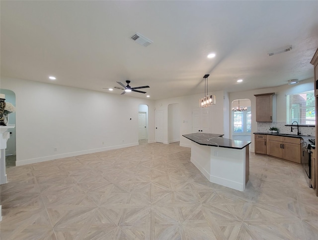 218 Windrift Ct, Sugar Land, TX 77479 - kitchen featuring arched walkways, dark countertops, recessed lighting, a sink, and ceiling fan