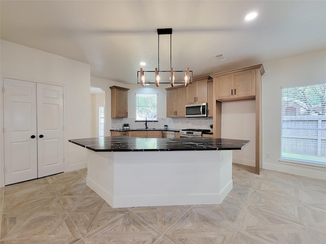 218 Windrift Ct, Sugar Land, TX 77479 - kitchen featuring appliances with stainless steel finishes, baseboards, a center island, arched walkways, and decorative backsplash