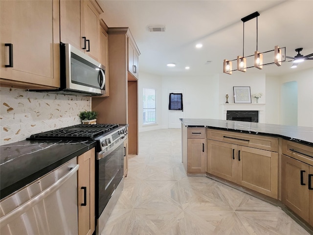218 Windrift Ct, Sugar Land, TX 77479 - kitchen with appliances with stainless steel finishes, recessed lighting, decorative backsplash, a fireplace, and pendant lighting