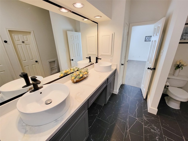 218 Windrift Ct, Sugar Land, TX 77479 - bathroom featuring baseboards, toilet, marble finish flooring, double vanity, and recessed lighting