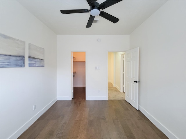 218 Windrift Ct, Sugar Land, TX 77479 - unfurnished bedroom featuring wood finished floors, a spacious closet, baseboards, ceiling fan, and a closet