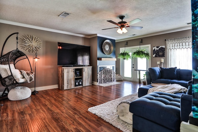 434 Lakeside Dr, Kemah, TX 77565 - living area featuring ceiling fan, wood finished floors, crown molding, a textured ceiling, and a fireplace