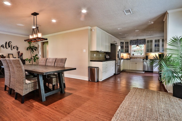 434 Lakeside Dr, Kemah, TX 77565 - dining space featuring dark wood finished floors, ornamental molding, recessed lighting, and a chandelier