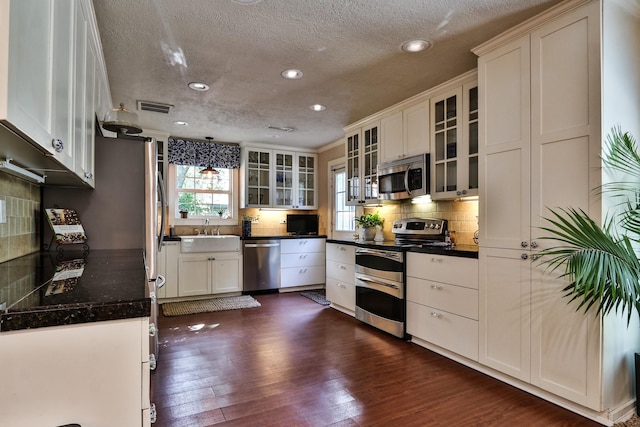 434 Lakeside Dr, Kemah, TX 77565 - kitchen with stainless steel appliances, a textured ceiling, recessed lighting, backsplash, and dark wood finished floors