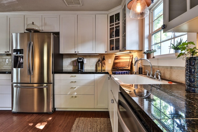 434 Lakeside Dr, Kemah, TX 77565 - kitchen with stainless steel appliances, glass insert cabinets, dark wood-type flooring, decorative backsplash, and dark countertops