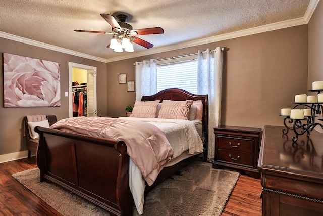 434 Lakeside Dr, Kemah, TX 77565 - bedroom with dark wood-style floors, a textured ceiling, ornamental molding, a walk in closet, and a ceiling fan