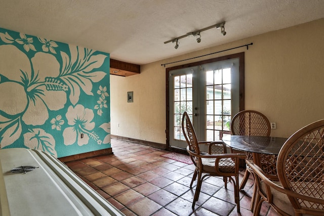 434 Lakeside Dr, Kemah, TX 77565 - dining room featuring french doors, a textured ceiling, rail lighting, and a textured wall