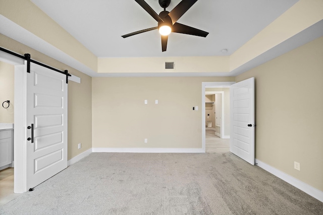 3107 Grassmere St A/B, Unit A/B Houston, TX 77051 - unfurnished bedroom with a barn door, light colored carpet, baseboards, ceiling fan, and ensuite bathroom
