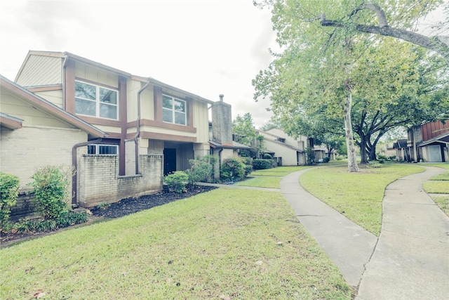 12553 Wellington Park Dr, Houston, TX 77072 - view of home's exterior featuring brick siding, a yard, and a chimney