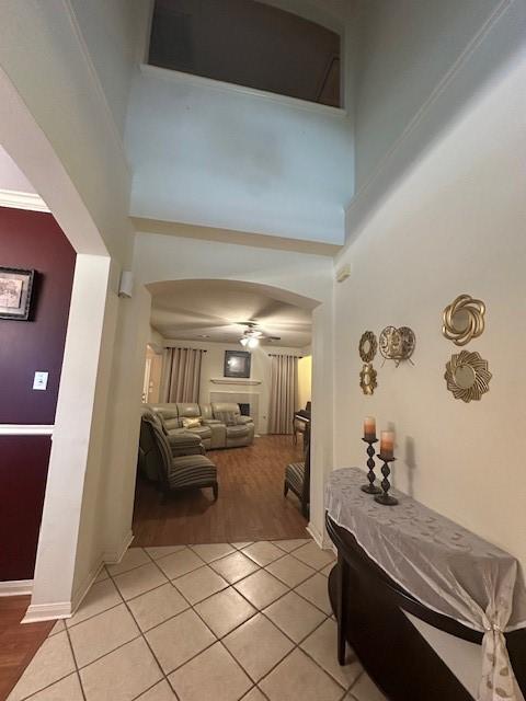 14602 Harcourt Bridge Ct, Houston, TX 77084 - hallway featuring a high ceiling, light tile patterned flooring, arched walkways, and baseboards