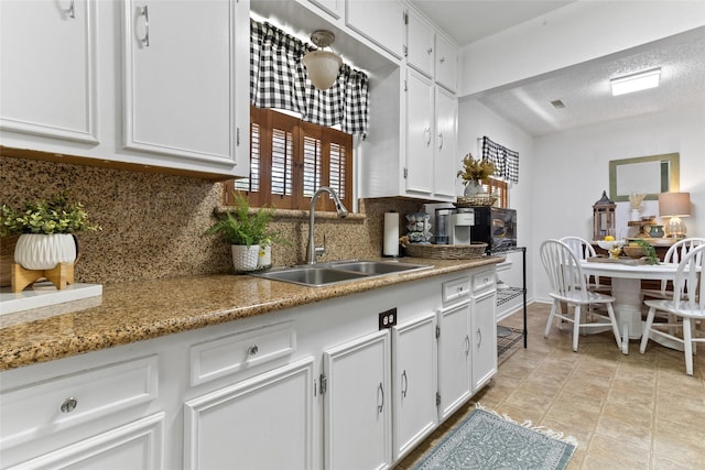 315 Cypress St, Lake Jackson, TX 77566 - kitchen featuring a sink, tasteful backsplash, white cabinetry, and a textured ceiling