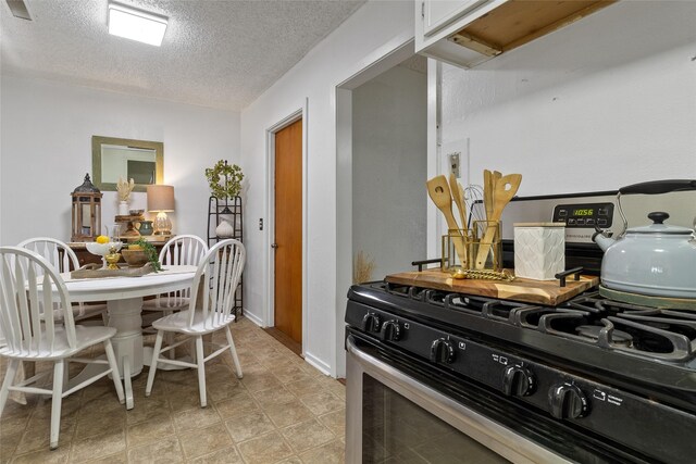 315 Cypress St, Lake Jackson, TX 77566 - kitchen featuring gas range, a textured ceiling, and white cabinets