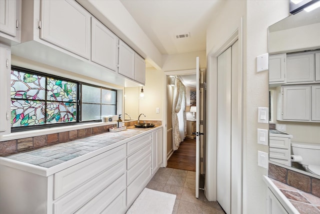 14111 Decker Dr, Magnolia, TX 77355 - kitchen featuring a sink, light countertops, white cabinets, and light tile patterned flooring