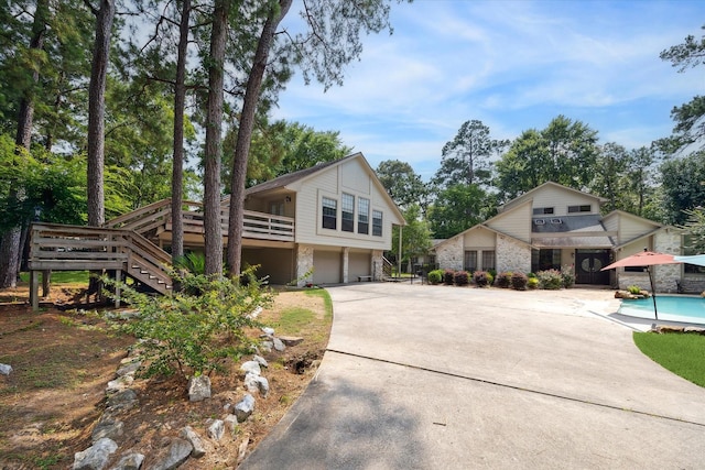 14111 Decker Dr, Magnolia, TX 77355 - view of front of property with an attached garage, stairs, driveway, an outdoor pool, and a deck