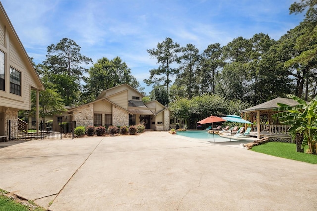 14111 Decker Dr, Magnolia, TX 77355 - view of front of home with stone siding, an outdoor pool, and a patio