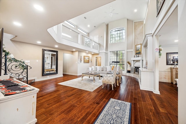 14111 Decker Dr, Magnolia, TX 77355 - living area with wood-type flooring, baseboards, a fireplace with raised hearth, and a high ceiling