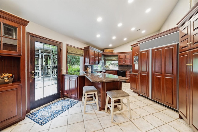 14111 Decker Dr, Magnolia, TX 77355 - kitchen featuring dishwasher, a peninsula, a kitchen breakfast bar, light tile patterned floors, and vaulted ceiling