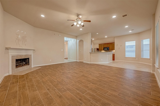 722 Silver Creek Cir, Richmond, TX 77406 - unfurnished living room featuring a fireplace, ceiling fan, light wood-type flooring, baseboards, and recessed lighting