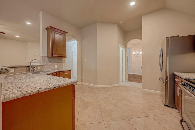 722 Silver Creek Cir, Richmond, TX 77406 - kitchen with a sink, arched walkways, stove, recessed lighting, and decorative backsplash