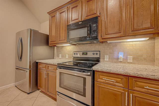 722 Silver Creek Cir, Richmond, TX 77406 - kitchen with stainless steel appliances, light tile patterned floors, lofted ceiling, backsplash, and brown cabinets