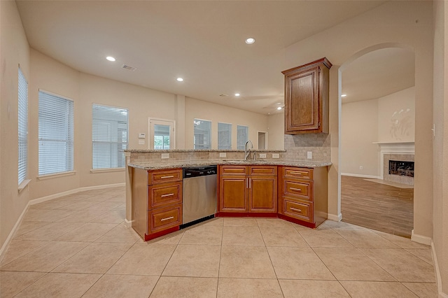 722 Silver Creek Cir, Richmond, TX 77406 - kitchen featuring stainless steel dishwasher, brown cabinets, tasteful backsplash, light tile patterned floors, and recessed lighting