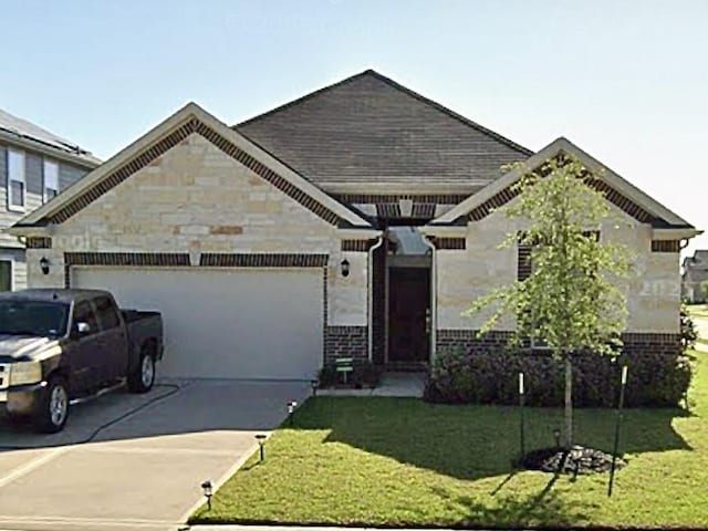 2115 Katalonia Ln, Fresno, TX 77545 - view of front of house featuring driveway, a garage, a front yard, stone siding, and brick siding