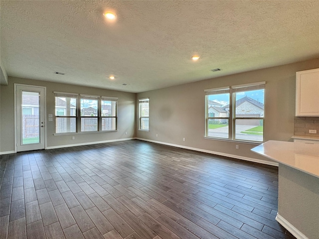 2115 Katalonia Ln, Fresno, TX 77545 - unfurnished living room with a textured ceiling, baseboards, dark wood finished floors, and recessed lighting