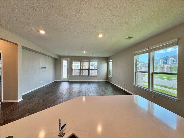 2115 Katalonia Ln, Fresno, TX 77545 - unfurnished living room with dark wood-type flooring, a textured ceiling, baseboards, and recessed lighting