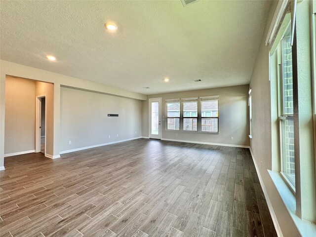 2115 Katalonia Ln, Fresno, TX 77545 - empty room with wood finished floors, a textured ceiling, baseboards, and recessed lighting