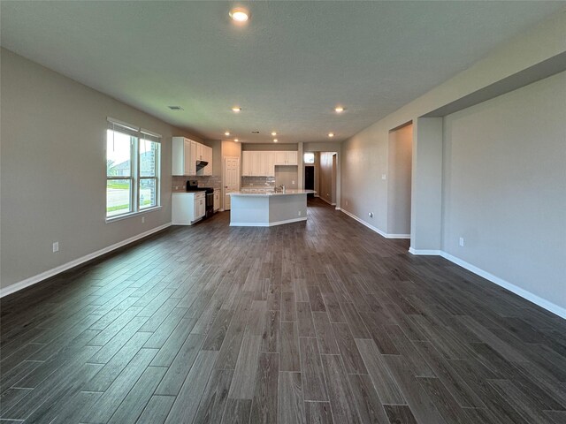 2115 Katalonia Ln, Fresno, TX 77545 - unfurnished living room with dark wood-style flooring, baseboards, and recessed lighting
