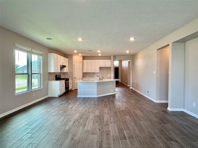 2115 Katalonia Ln, Fresno, TX 77545 - kitchen featuring stove, dark wood finished floors, a center island with sink, baseboards, and recessed lighting