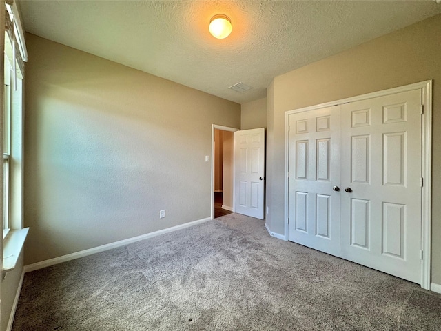 2115 Katalonia Ln, Fresno, TX 77545 - unfurnished bedroom featuring carpet, baseboards, a closet, and a textured ceiling