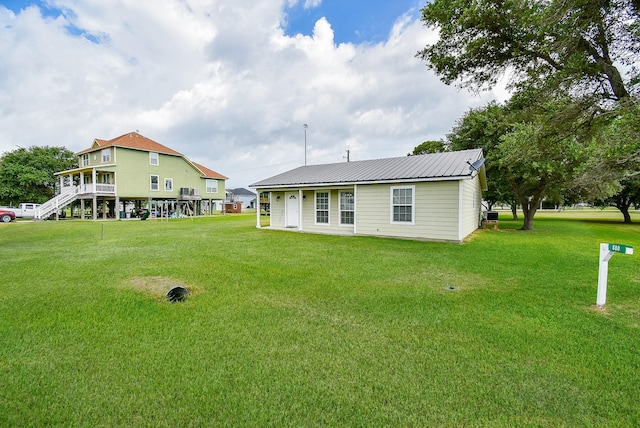 880 Swallow Dr, Palacios, TX 77465 - rear view of house featuring a yard and a metal roof