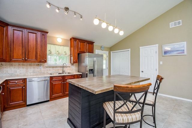 880 Swallow Dr, Palacios, TX 77465 - kitchen with appliances with stainless steel finishes, backsplash, light countertops, light tile patterned flooring, and a breakfast bar