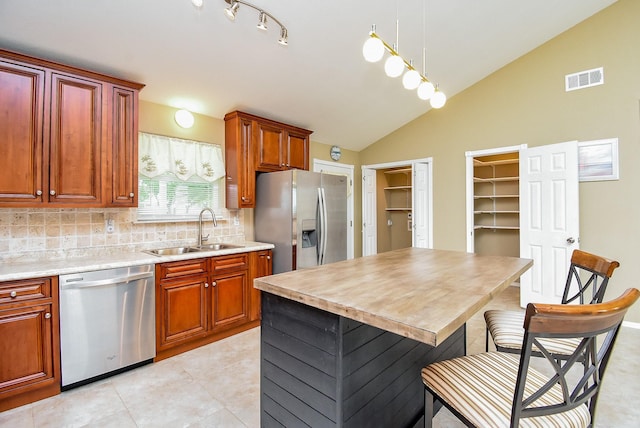 880 Swallow Dr, Palacios, TX 77465 - kitchen with stainless steel appliances, tasteful backsplash, lofted ceiling, light countertops, and light tile patterned floors