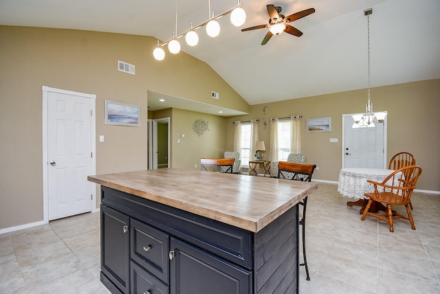 880 Swallow Dr, Palacios, TX 77465 - kitchen featuring light tile patterned floors, a ceiling fan, pendant lighting, wooden counters, and high vaulted ceiling