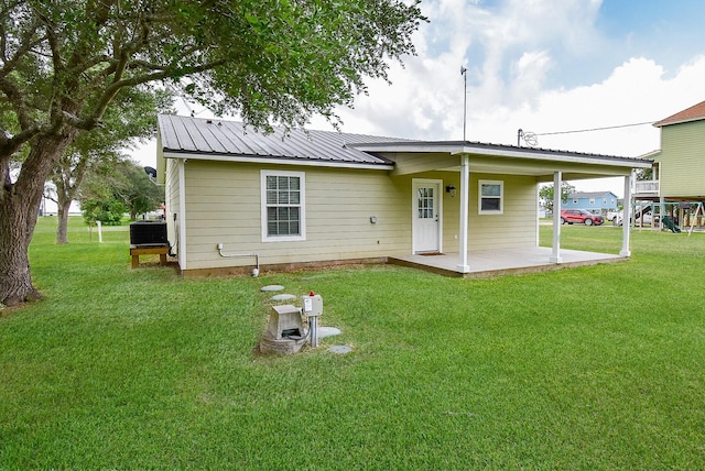 880 Swallow Dr, Palacios, TX 77465 - rear view of house featuring a yard, a carport, and a metal roof