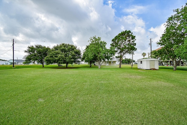880 Swallow Dr, Palacios, TX 77465 - view of green lawn featuring a storage unit