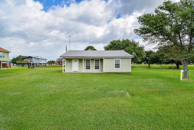 880 Swallow Dr, Palacios, TX 77465 - back of property with a yard and a metal roof