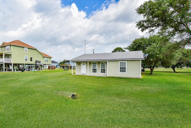 880 Swallow Dr, Palacios, TX 77465 - back of house featuring a lawn and a metal roof