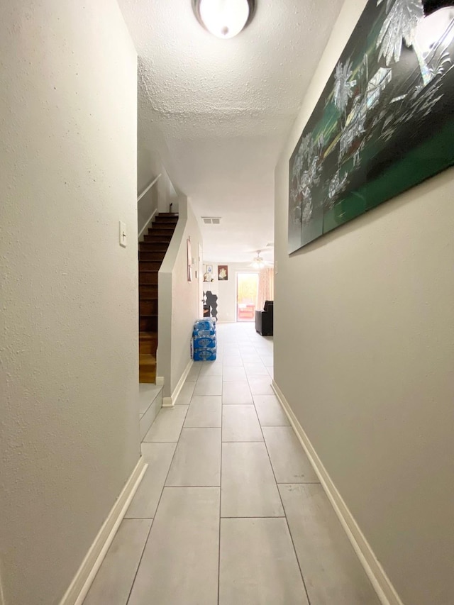 8323 Wilcrest Dr Unit 2006, Houston, TX 77072 - corridor featuring stairway, tile patterned floors, baseboards, and a textured ceiling