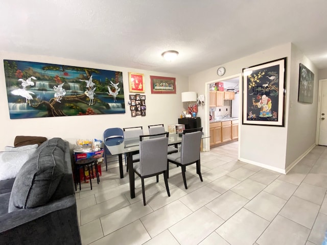 8323 Wilcrest Dr Unit 2006, Houston, TX 77072 - dining area featuring light tile patterned flooring, baseboards, and a textured ceiling