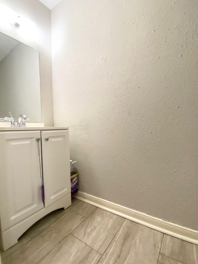8323 Wilcrest Dr Unit 2006, Houston, TX 77072 - bathroom featuring vanity, baseboards, and wood finished floors