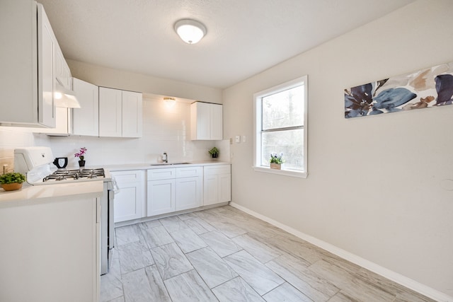 9306 Chesterfield Dr, Houston, TX 77051 - kitchen with white gas range oven, a sink, white cabinetry, and light countertops