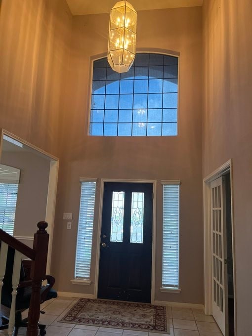 6603 Golden View Ct, Houston, TX 77083 - tiled entryway with a chandelier, a towering ceiling, and baseboards