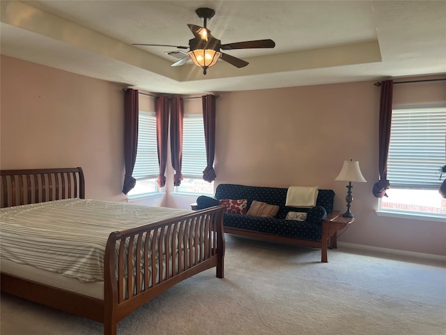 6603 Golden View Ct, Houston, TX 77083 - bedroom featuring carpet flooring, a tray ceiling, multiple windows, and a ceiling fan