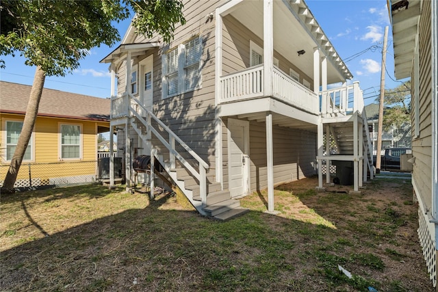 801 University Blvd, Galveston, TX 77550 - rear view of house featuring stairway and a lawn