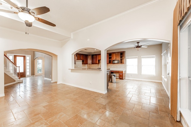 12515 Country Arbor Ln, Houston, TX 77041 - unfurnished living room featuring a ceiling fan, stone tile flooring, healthy amount of natural light, ornamental molding, and arched walkways